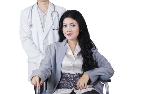 Patient sits on wheelchair with doctor in studio — Stock Photo, Image