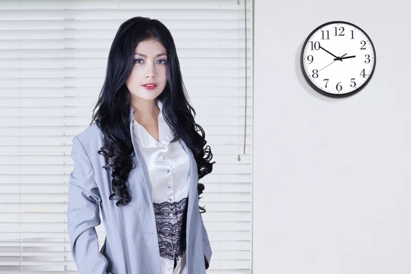 Pretty worker with a clock on the wall — Stock Photo, Image