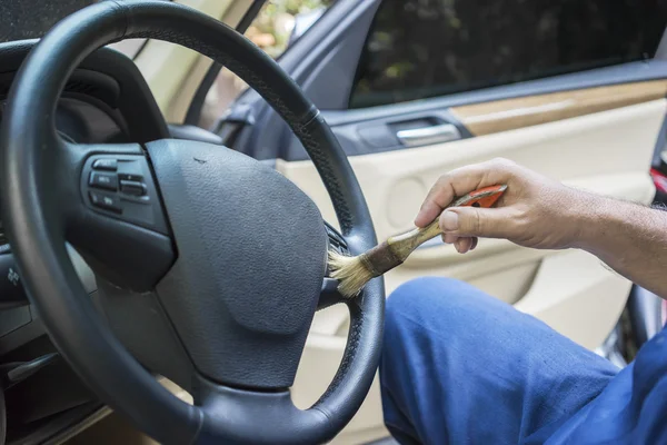 Trabalhador escovando um volante — Fotografia de Stock