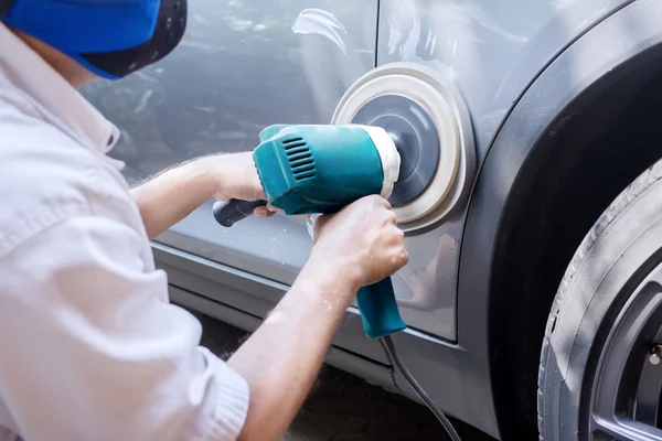 Arbetaren polera en bil med auto polermaskin — Stockfoto