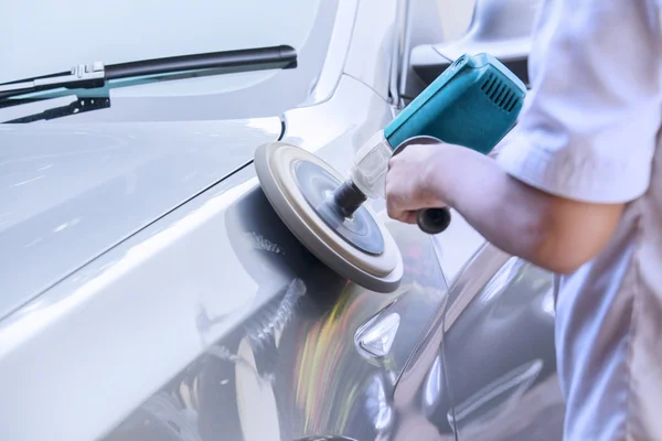 Trabajador encerando un coche con auto pulidor — Foto de Stock