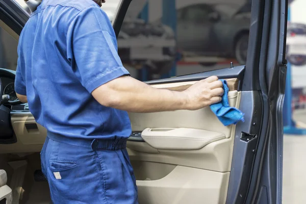Trabajador limpiando una puerta de coche con tela — Foto de Stock