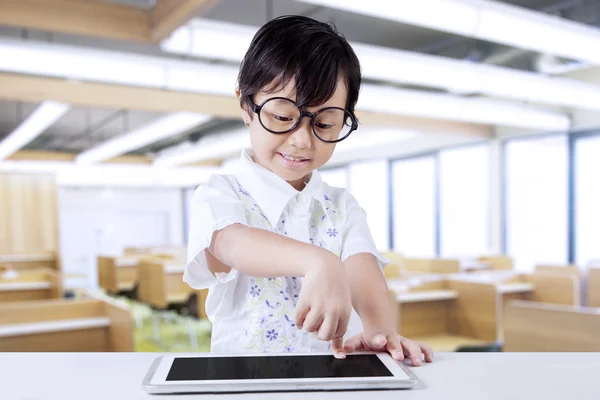 Menina bonito usando tablet na classe — Fotografia de Stock