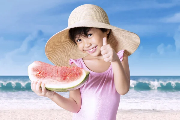 Meisje houdt een watermeloen op het strand — Stockfoto