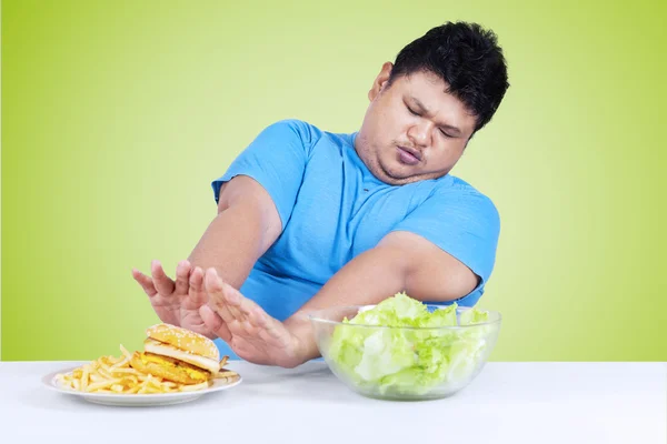 Hombre rechazar comida chatarra en el escritorio — Foto de Stock