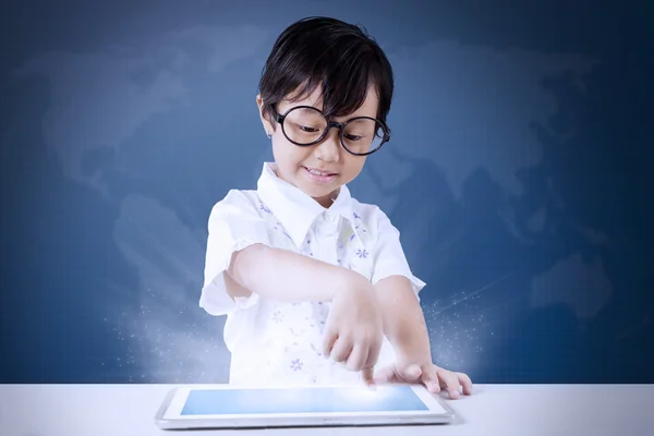 Niña utiliza tableta con fondo de mapa del mundo —  Fotos de Stock