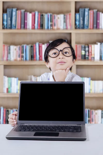 Schüler denken mit Laptop in Bibliothek — Stockfoto