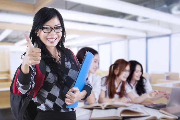 Student shows thumb up while her friends learning — Stock Photo, Image