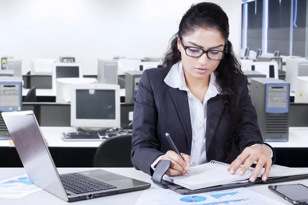 Arbetaren skriver en tidning i office — Stockfoto