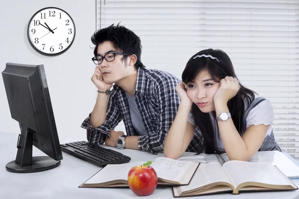 Dois estudantes entediados estudando juntos — Fotografia de Stock