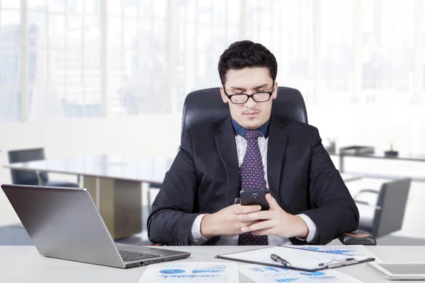 Arabian entrepreneur reading a message — Stock Photo, Image