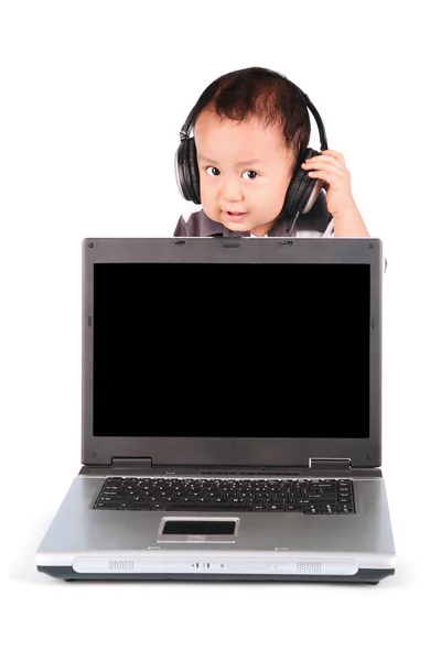 Baby met laptop en dragen hoofdtelefoons — Stockfoto