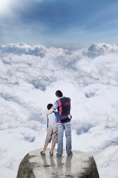 Homme debout sur la falaise avec son fils — Photo