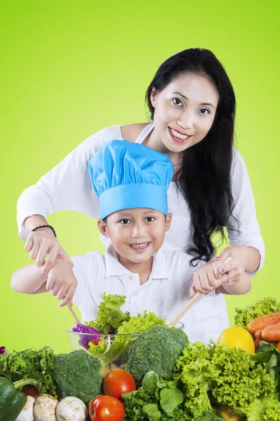 Niño y su madre mezclando ensalada — Foto de Stock