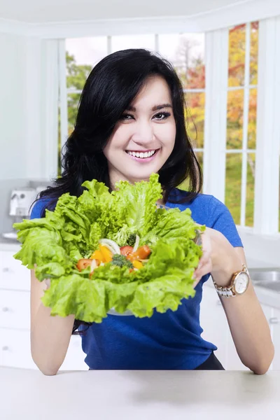 Chica joven muestra lechuga fresca — Foto de Stock