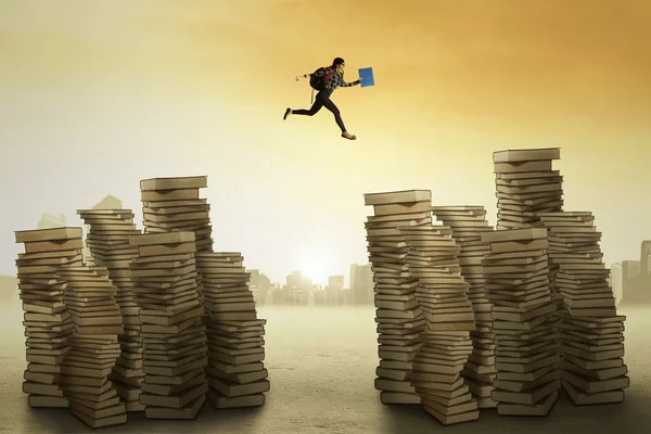 College student leaps over the books — Stock Photo, Image