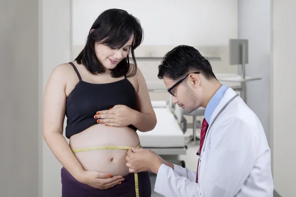 Lekarz sprawdzanie brzuch kobiety w ciąży — Zdjęcie stockowe