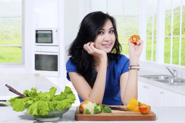 Pretty woman holds a slice of tomato — Stock Photo, Image