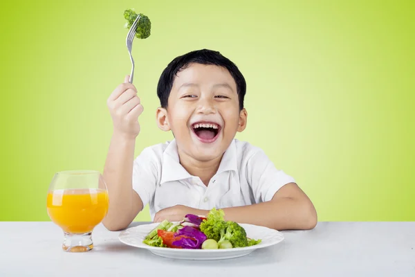 Kind salade eten en drinken sinaasappelsap — Stockfoto