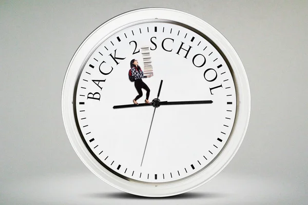 Młody student prowadzi książek na zegarze — Zdjęcie stockowe