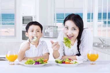 Küçük bir çocuk ve onun anne salata keyfini çıkarın