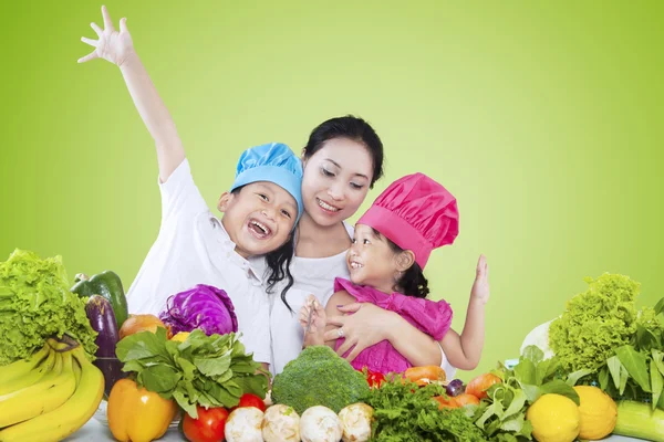 Crianças e sua mãe preparando legumes — Fotografia de Stock