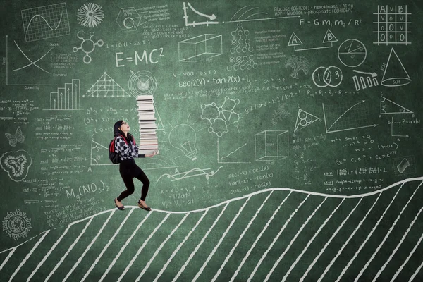 High school student with books on chalkboard — Stock Photo, Image