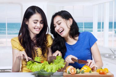 Salata çatalı iki neşeli kız