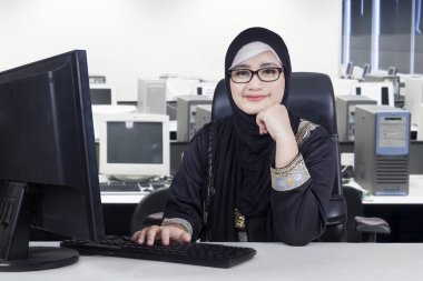 Ofiste gülümseyen genç bir Arap işçi