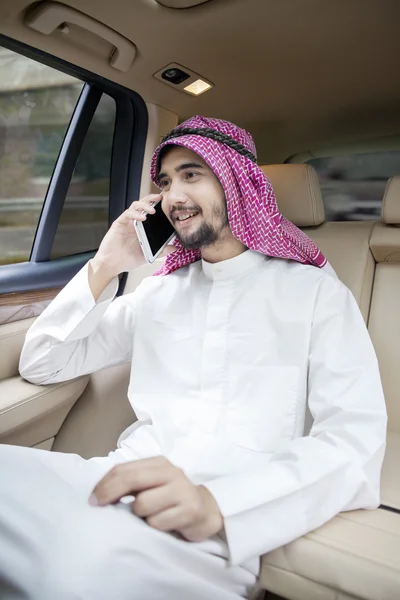 Arabiska man talar i mobiltelefon i bilen — Stockfoto