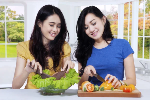 Asiatinnen bereiten Salat in der Küche zu — Stockfoto