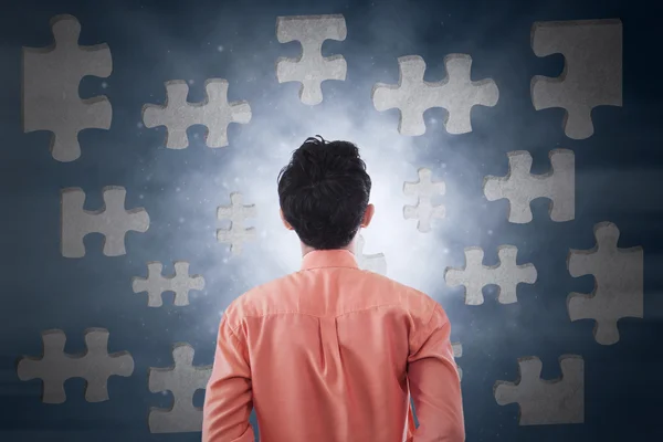 Male worker looking at puzzle