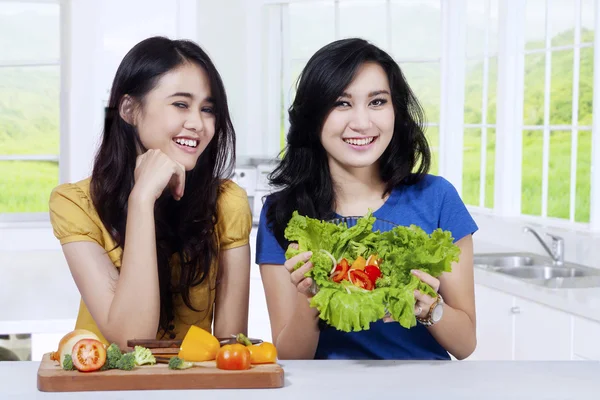 Two pretty model showing fresh salad — Stock Photo, Image