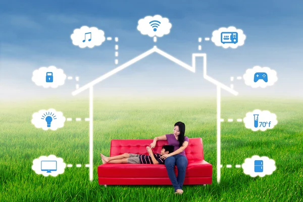 Woman and her son sit under smart house design — Stock Photo, Image