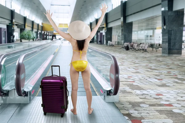 Mulher feliz vestindo biquíni no corredor do aeroporto — Fotografia de Stock