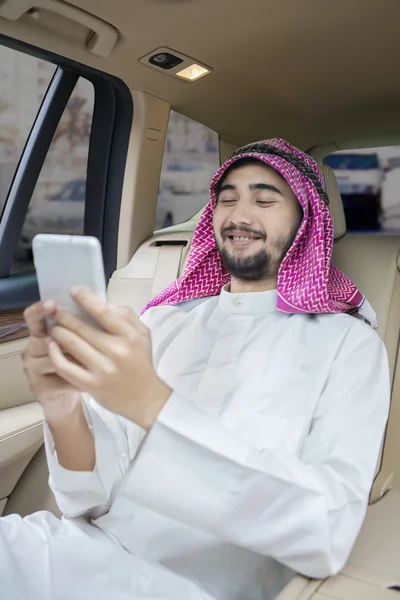 Arabiska person använder mobiltelefon i bilen — Stockfoto