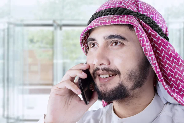 Hombre árabe hablando por celular en el vestíbulo de la oficina — Foto de Stock