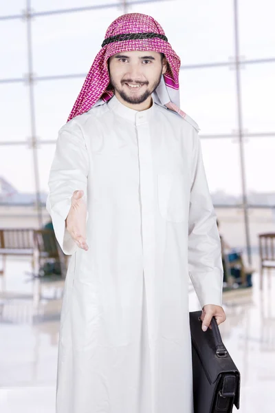 Arabský obchodník nabízí handshake na letišti — Stock fotografie