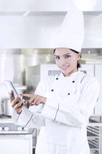 Aziatische chef-kok met behulp van mobiele telefoon in de keuken — Stockfoto