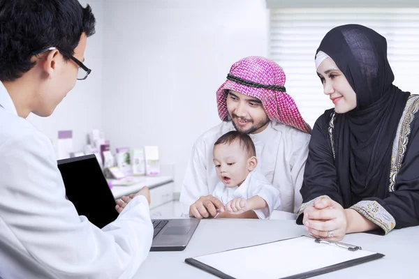 Lekarz pokazuje laptopa na arabski rodziny — Zdjęcie stockowe
