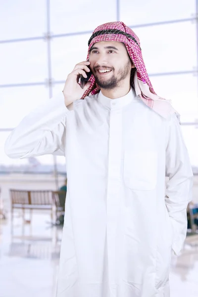 Аравійська працівник говорити на мобільний телефон в аеропорту — стокове фото