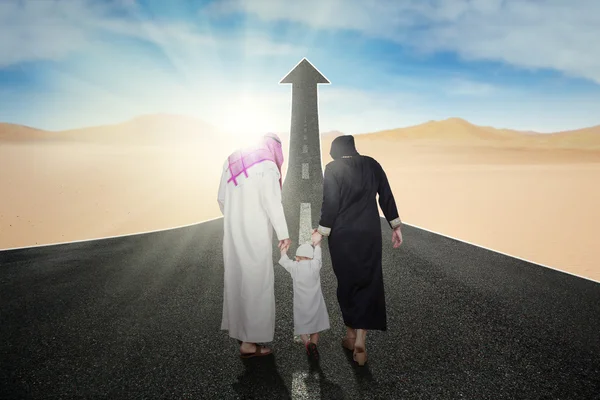 Арабская семья на дороге со стрелой вверх — стоковое фото
