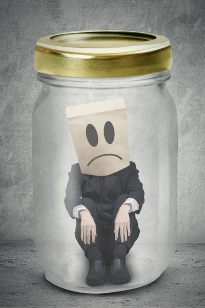 Male worker sitting inside a jar — Stock Photo, Image