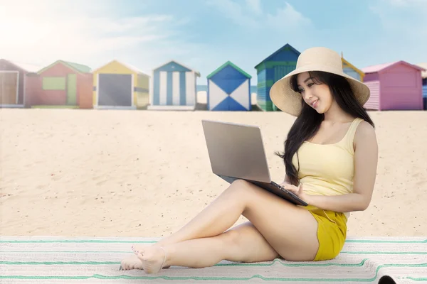 Frau arbeitet mit Laptop am Strand — Stockfoto