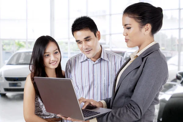 Car seller with young couple — Stock Photo, Image