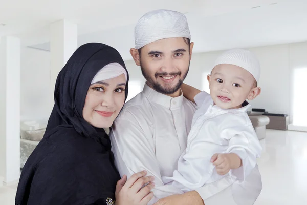 Familia musulmana sonriendo a la cámara en casa —  Fotos de Stock