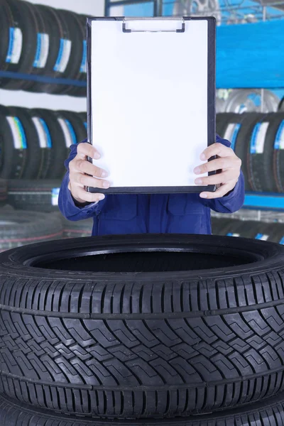 Mechanic holds clipboard in workshop — Stock Photo, Image