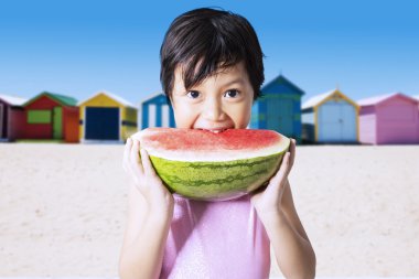 Güzel çocuk karpuz Coast'ta yiyor.