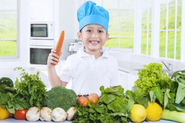 Sevimli çocuk mutfakta bir havuç holding