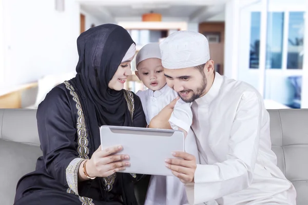 Glückliche muslimische Familie nutzt Tablet auf dem Sofa — Stockfoto